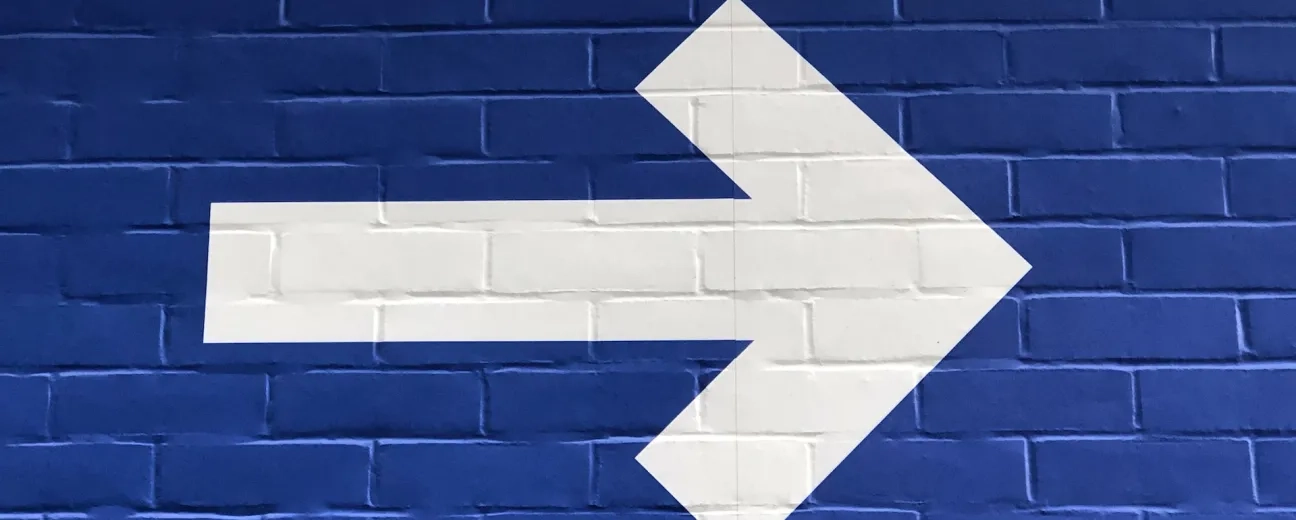 white arrow on brick wall