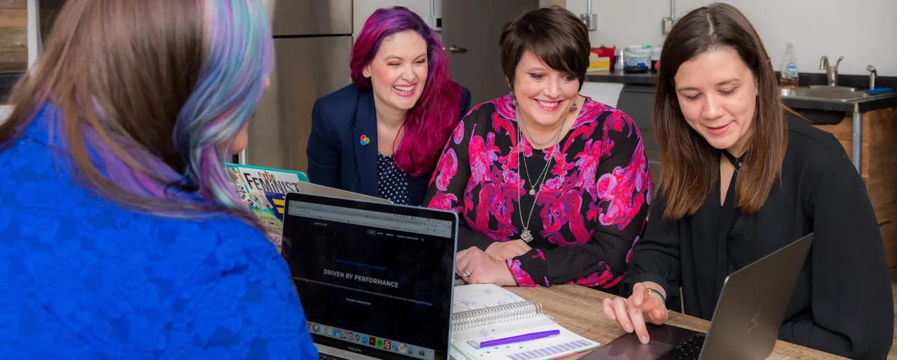 women using laptops and smiling