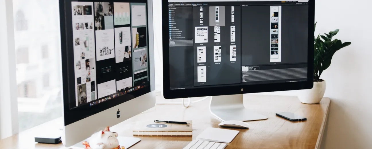 Web design checklist displayed across dual monitors on a designer's desk