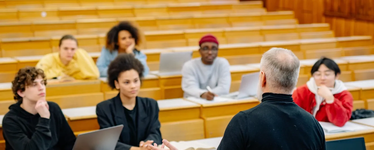 Professor lecturing a diverse group of students in a university lecture hall