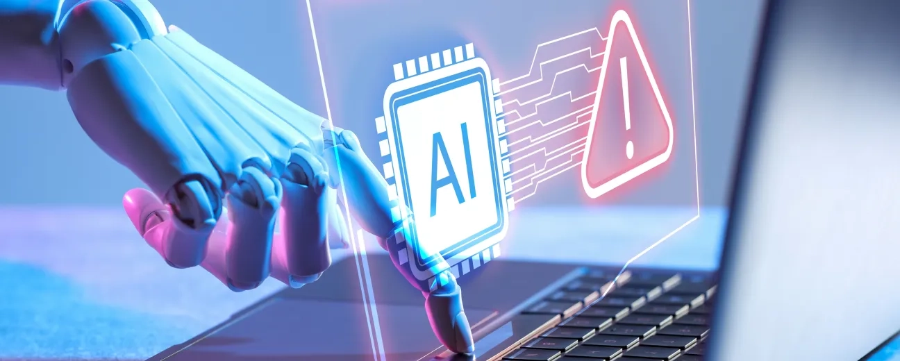 Robotic hand typing on a laptop with a glowing AI chip and warning sign hologram illustrating cybersecurity threats