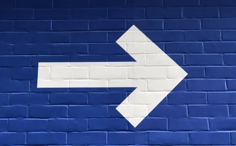white arrow on brick wall
