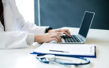 Doctor typing on a laptop